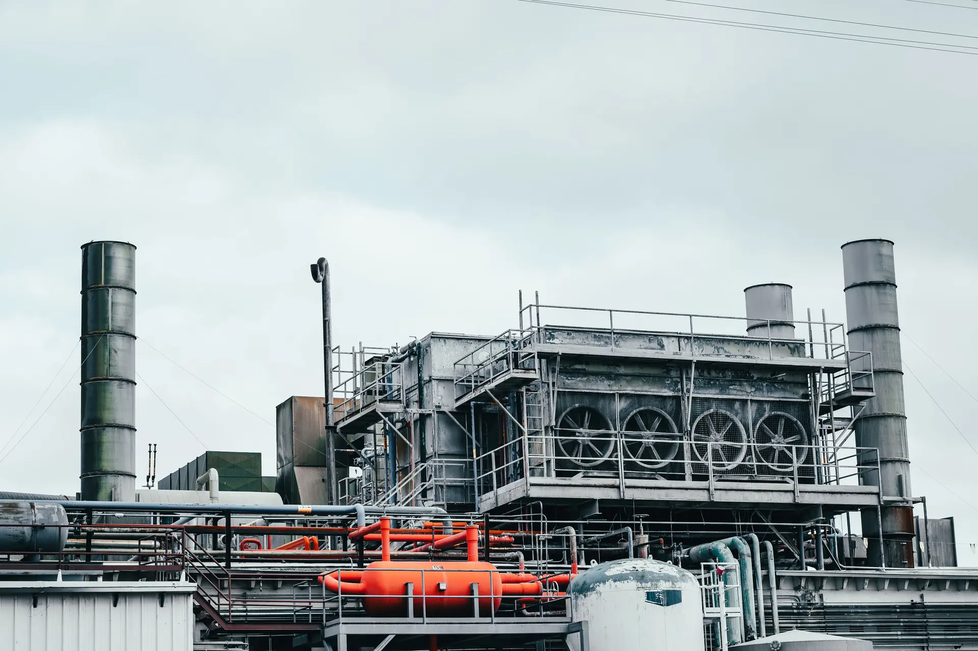 Industrial plant with stacks, cooling fans and pipework