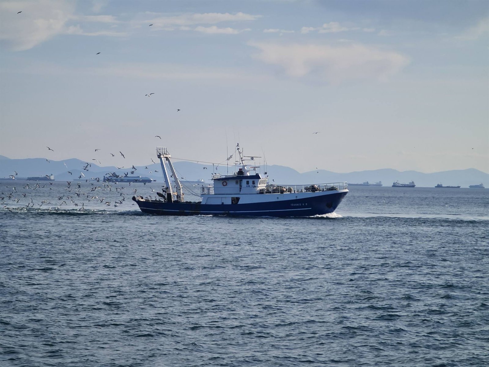 Commercial fishing trawler under way with seabirds following